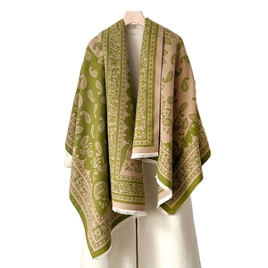 Olivgrüner und beige Paisley Schal mit Fransen auf einem Holzbügel hängend