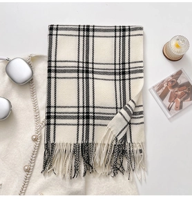 Macro detail of checkered scarf with soft knit texture and fringe tassels in black and white