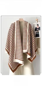 Dettaglio della sciarpa pied-de-poule marrone e beige con nappe fini e morbide