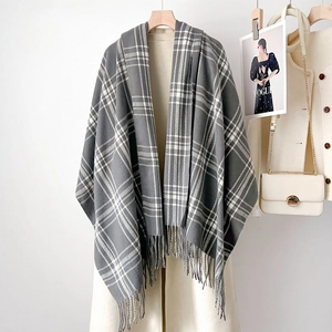 Thick two-tone grey and white checked scarf with fringes on a hanger for winter