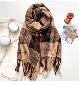 Detail shot of plaid thick winter shawl with long tassels and soft fabric texture