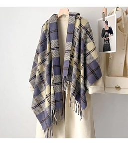 Detailed close-up of thickened plaid shawl with tassels on elegant beige coat