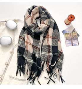 Close-up of thick plaid tassel scarf featuring classic British check patterns and soft fringe