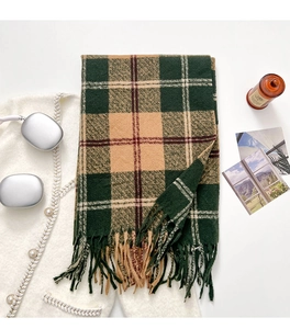 Detailed close-up of thick green and khaki plaid scarf with fringe and soft texture