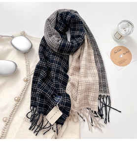 Flat lay di una sciarpa a quadri con nappe, cuffie e candela in stile invernale