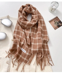 Detail of soft cashmere scarf with plaid pattern, fringe edges and stylish winter accessories
