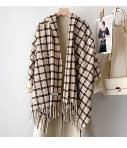 Detail of classic plaid scarf with fringe trim paired with a stylish beige winter coat