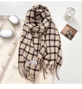 Macro view of checkered cashmere scarf with fringe edges and brand label on white coat
