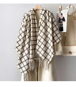 Detailed view of thick beige and brown checkered scarf with soft tassel fringe