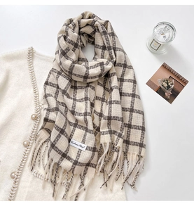 Detail of checkered cashmere scarf with fringes and label on tweed cardigan jacket