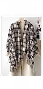 Detail of soft plaid scarf showing thick cashmere-like fabric and long fringe edges
