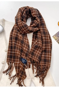 Detail of soft cashmere-like plaid scarf with fringe tassels and woven brand label