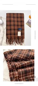 Macro shot of brown plaid imitation cashmere scarf fabric texture and tassel detail