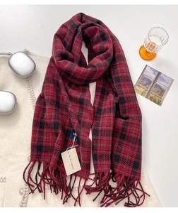 Close-up of thick red and black plaid cashmere scarf with soft fringes and rich texture