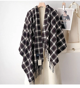 Close-up of black and red plaid scarf with fringe detail on a white winter coat