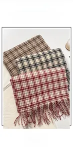Detail view of thick winter scarves with classic plaid patterns and soft fringed edges