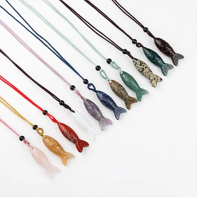 Macro view of multi-color fish-shaped semi-precious stone pendants on woven cords