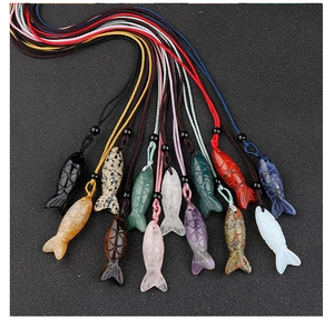 Detailed view of hand-carved fish pendants in various natural semi-precious gemstones