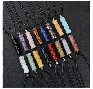 Vue macro de divers pendentifs en améthyste et agate en forme de bambou avec cordons noirs