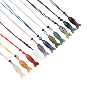 Natural amethyst and agate fish-shaped pendants with woven cords on white background