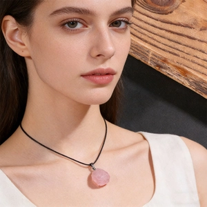 Natural pink quartz raw stone pendant necklace with simple black cord on model