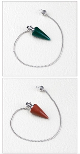 Detailansicht von grünen und rotbraunen Edelstein-Pendeln mit silbernen Ketten.
