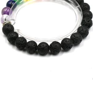 Chakra lava stone bracelet with colorful crystal beads on a white circular display stand