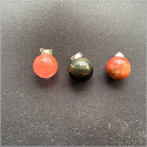 Gros plan de pendentifs ronds en pierre naturelle avec attaches en métal poli