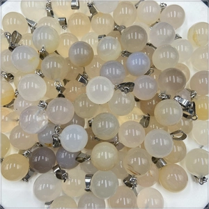 Gros plan de divers pendentifs boules en quartz et agate translucide avec fermoirs argent