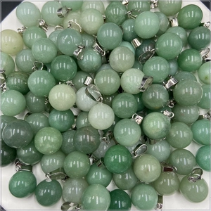 Détail de pendentifs sphériques en cristal vert clair poli avec bélières en métal argenté