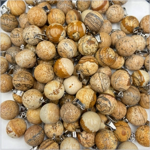 Gros plan de pendentifs ronds en jaspe naturel avec attaches en acier inoxydable argenté