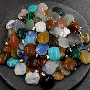 Macro shot of assorted colorful apple-shaped natural stone pendants on a white plate