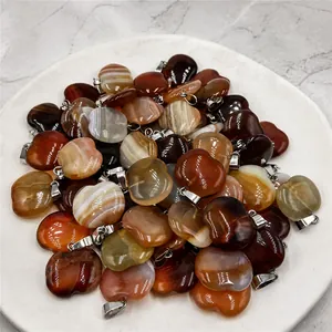 Close-up of apple-shaped natural striped agate pendants with polished silver metal bails