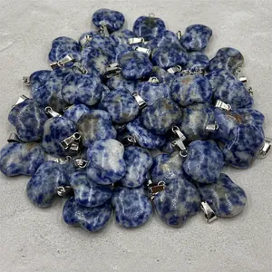 Detailed close-up of blue sodalite apple pendants with silver bails on a white stand