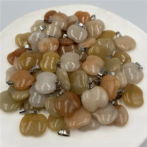 Close-up of apple-shaped natural stone pendants with silver clasps in various colors