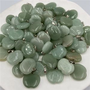 Pile of light green apple-shaped stone pendants with silver metal clasps on white dish