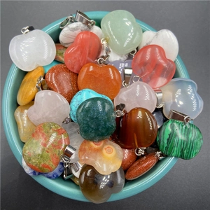 Close-up of assorted heart and apple-shaped natural stone pendants with silver clasps