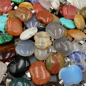 Macro detail of various colorful apple-shaped natural stone pendants with silver clasps