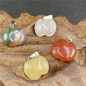 Natural gemstone apple pendants in pink crystal, red agate, and yellow citrine on wood