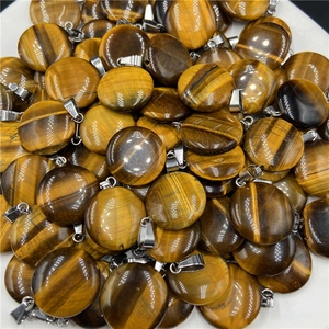 Dettaglio macro di ciondoli in occhio di tigre naturale con trame di seta dorate uniche