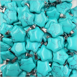 Close-up of star-shaped turquoise stone pendants with silver metal clasps and mineral veins
