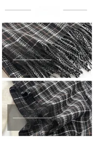 Gros plan sur une écharpe à carreaux noirs et blancs avec maille sergé et détails à franges