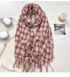 Detailed view of red and white plaid scarf with soft fringe tassels on a lifestyle set