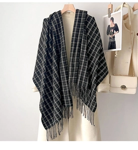 Détail d'une écharpe à carreaux noirs et blancs avec franges sur un manteau
