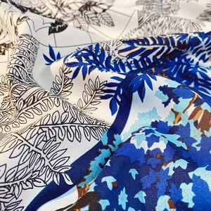 Detailed close-up of premium satin silk scarf featuring tropical leaf and floral prints