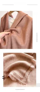 Detailed view of brick red imitation cashmere scarf featuring fine herringbone texture and fringe