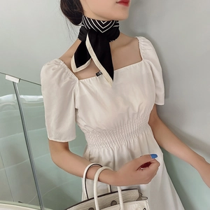 Foulard en soie à rayures noires et beige style français noué pour un look élégant