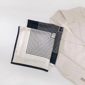 Gros plan d'un foulard en soie rayé avec un motif géométrique minimaliste noir et blanc