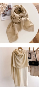 Detail of minimalist beige long scarf with raw fringe edges styled for summer outfits