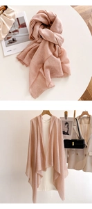 Detail of light pink summer shawl with fine fringe edges and breathable fabric texture